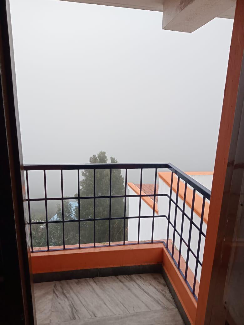 Misty balcony view at Orange Cottage, Kodaikanal